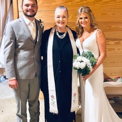 Sarah with a couple in a barn venue
