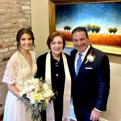 Sarah with a couple beside a gallery mural